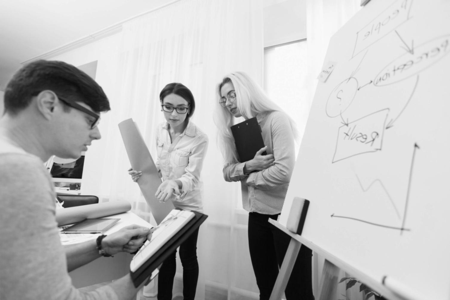Business professionals reviewing design improvements and user interface mockups on digital devices
